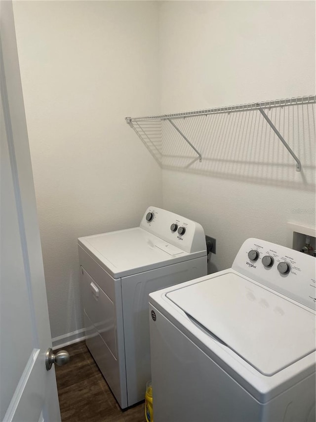 laundry room with washing machine and dryer and dark hardwood / wood-style floors