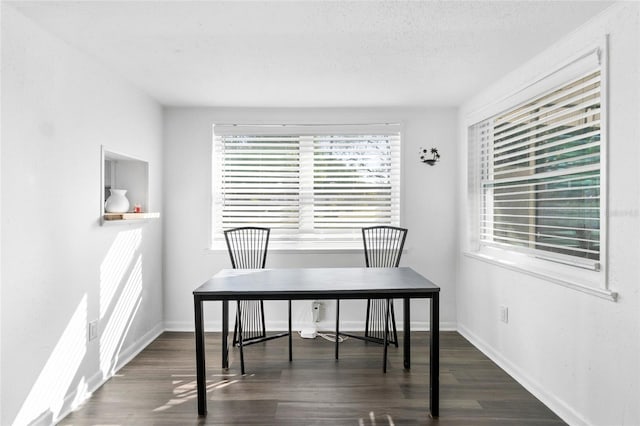 dining space featuring dark hardwood / wood-style floors and a textured ceiling