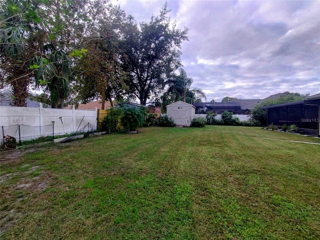 view of yard with an outbuilding, a storage shed, and a fenced backyard