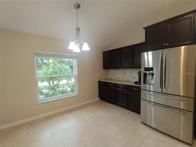 kitchen with backsplash, light countertops, lofted ceiling, an inviting chandelier, and stainless steel refrigerator with ice dispenser