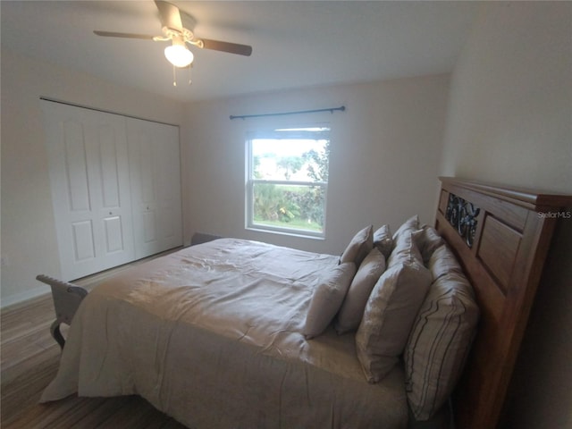 bedroom featuring a closet, baseboards, wood finished floors, and a ceiling fan