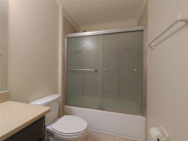 bathroom featuring tile patterned floors, toilet, vanity, and enclosed tub / shower combo