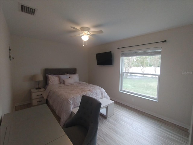 bedroom with a ceiling fan, light wood-style flooring, baseboards, and visible vents