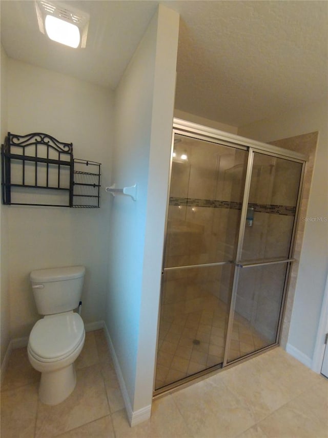 full bathroom featuring tile patterned floors, a stall shower, toilet, and baseboards