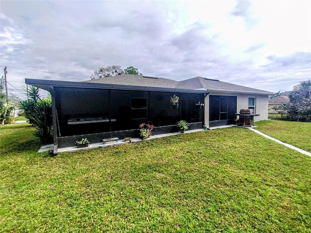 rear view of property with a yard and a sunroom