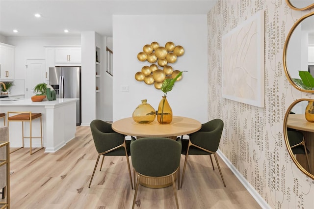 dining area featuring sink and light hardwood / wood-style flooring