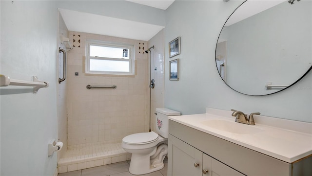 bathroom with tile patterned floors, vanity, toilet, and tiled shower