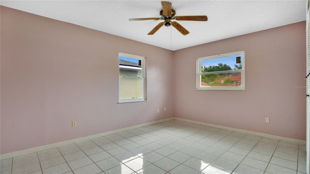 tiled spare room featuring ceiling fan