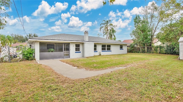 back of property with a lawn and a sunroom