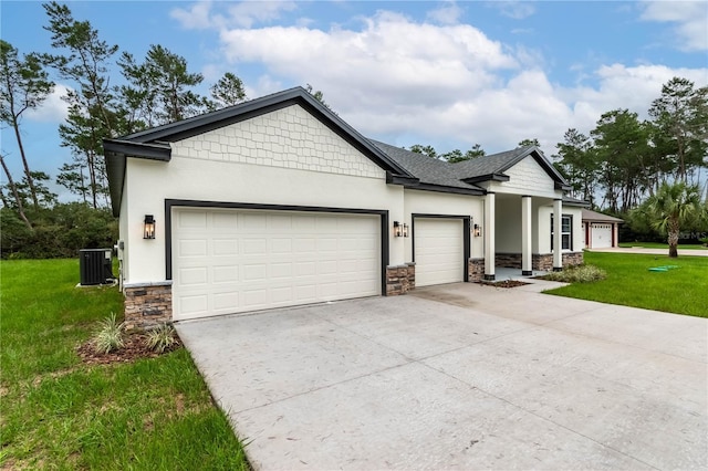 view of front facade with a front yard, central AC unit, and a garage