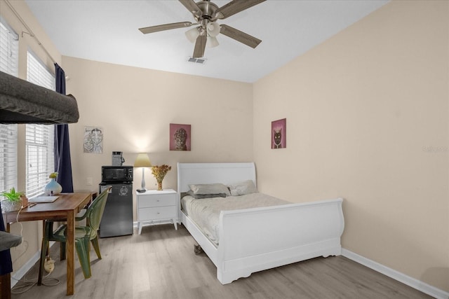 bedroom featuring ceiling fan, wood-type flooring, and multiple windows