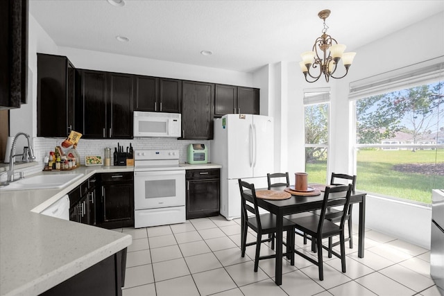 kitchen featuring sink, an inviting chandelier, decorative light fixtures, white appliances, and decorative backsplash