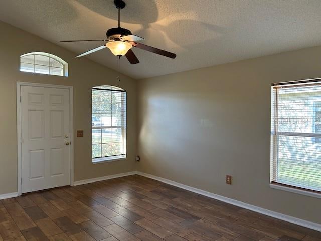 foyer featuring a textured ceiling, dark hardwood / wood-style flooring, vaulted ceiling, and ceiling fan