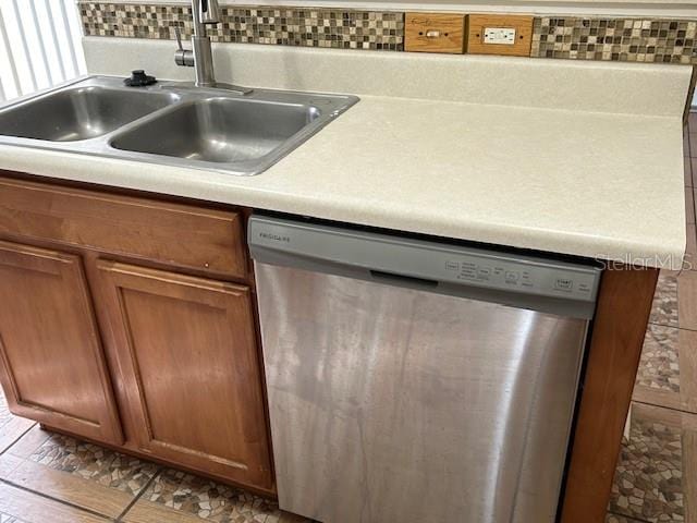 kitchen with dishwasher, light wood-type flooring, tasteful backsplash, and sink