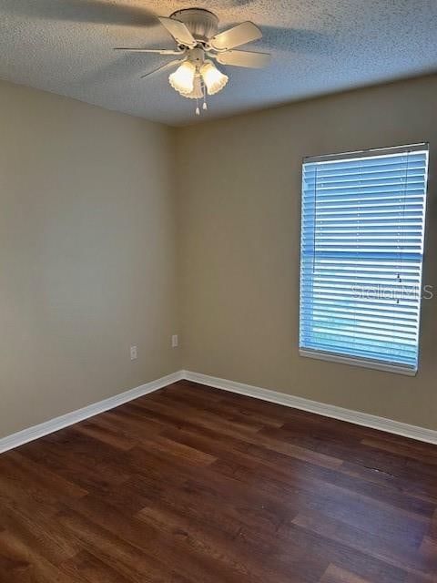 spare room featuring a textured ceiling, ceiling fan, and dark hardwood / wood-style floors