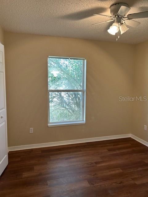 unfurnished room with a textured ceiling, dark hardwood / wood-style flooring, and ceiling fan