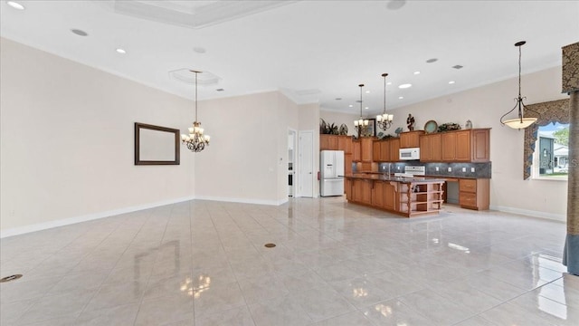 kitchen featuring backsplash, white appliances, a center island with sink, a chandelier, and hanging light fixtures