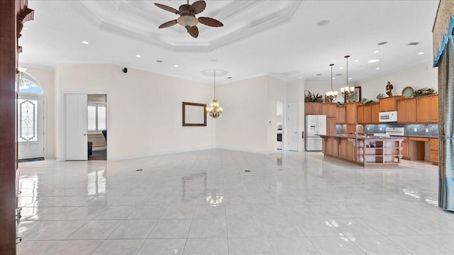 tiled living room featuring ceiling fan with notable chandelier, sink, and crown molding