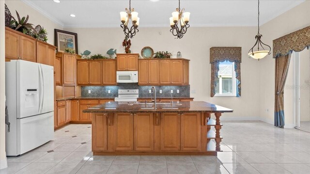 kitchen featuring sink, an inviting chandelier, crown molding, white appliances, and a kitchen island with sink