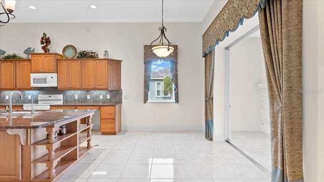 kitchen with sink, pendant lighting, white appliances, decorative backsplash, and light tile patterned floors