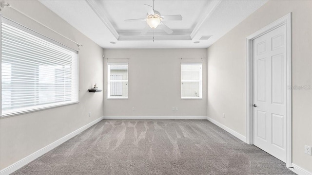 carpeted empty room with a tray ceiling, ceiling fan, and ornamental molding