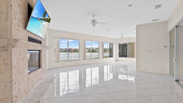 unfurnished living room with ceiling fan and light tile patterned floors