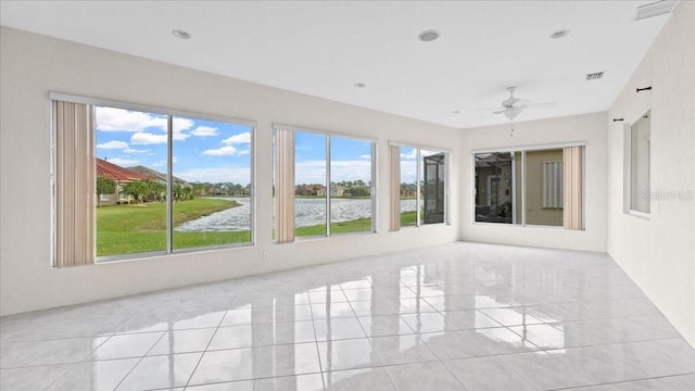 unfurnished sunroom featuring a water view and ceiling fan