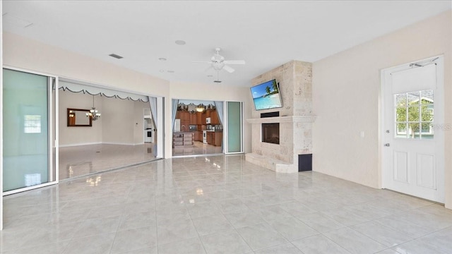 unfurnished living room with ceiling fan and a fireplace