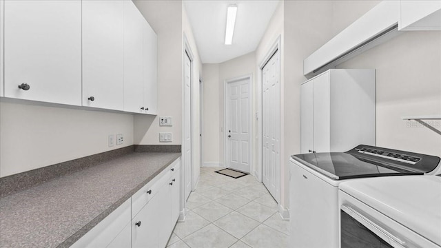 laundry room with cabinets, washing machine and dryer, and light tile patterned floors