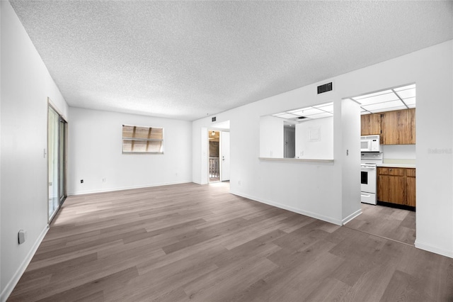 unfurnished living room with hardwood / wood-style floors and a textured ceiling