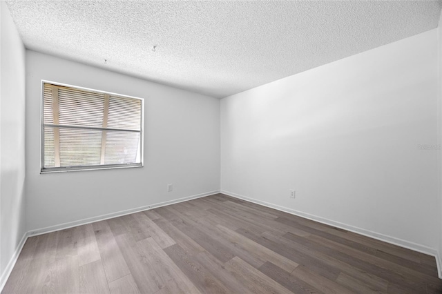 empty room featuring a textured ceiling and hardwood / wood-style flooring