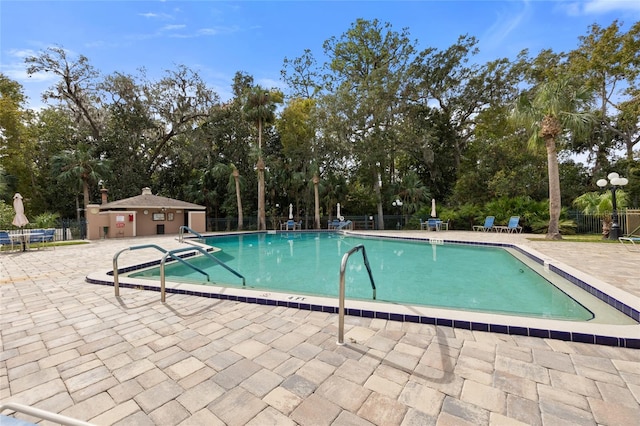 view of swimming pool featuring an outdoor structure and a patio