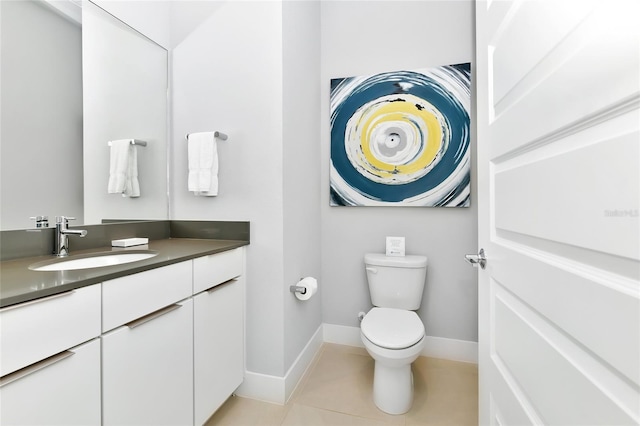 bathroom with toilet, vanity, and tile patterned floors