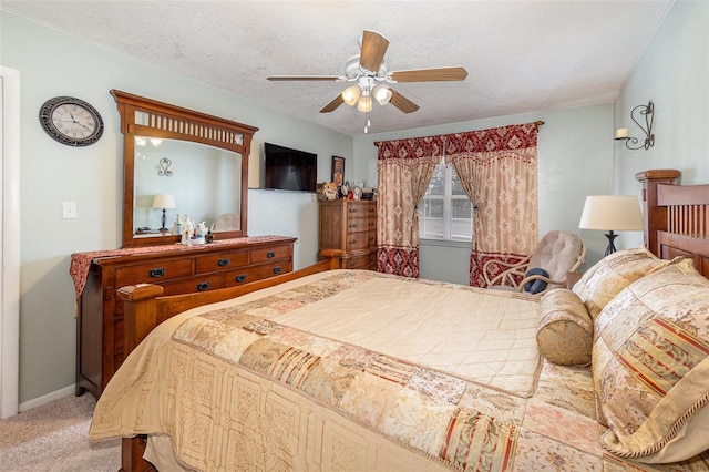 carpeted bedroom with ceiling fan and a textured ceiling