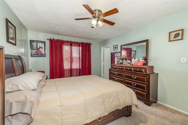 bedroom with a textured ceiling, light colored carpet, and ceiling fan