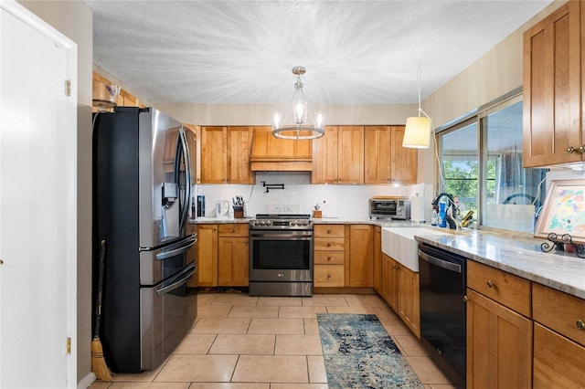 kitchen featuring pendant lighting, an inviting chandelier, light stone countertops, appliances with stainless steel finishes, and light tile patterned flooring