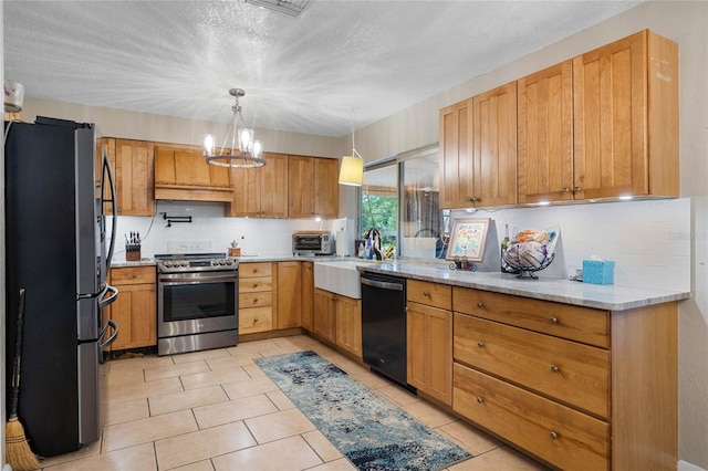 kitchen featuring light stone countertops, a chandelier, a textured ceiling, decorative light fixtures, and appliances with stainless steel finishes