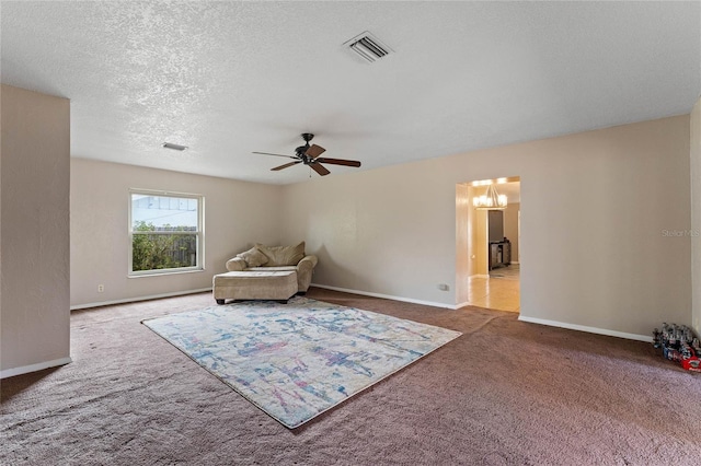 living area featuring carpet, a textured ceiling, and ceiling fan with notable chandelier