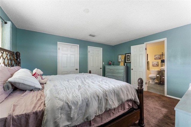 carpeted bedroom featuring a textured ceiling and ensuite bath