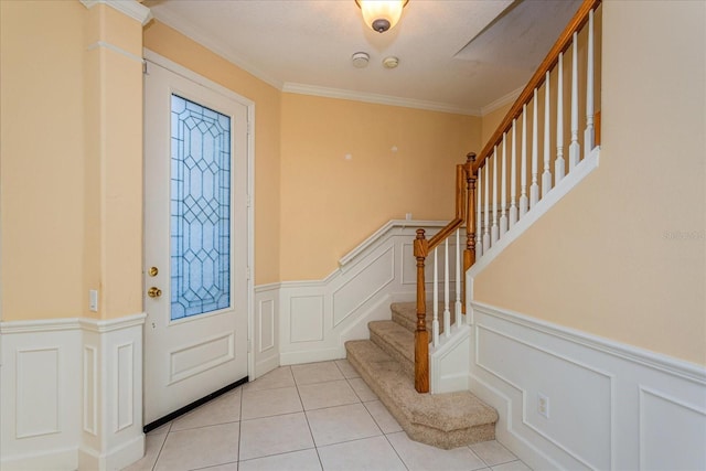 tiled entryway featuring crown molding