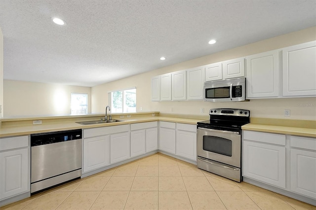 kitchen featuring white cabinets, appliances with stainless steel finishes, a textured ceiling, and sink