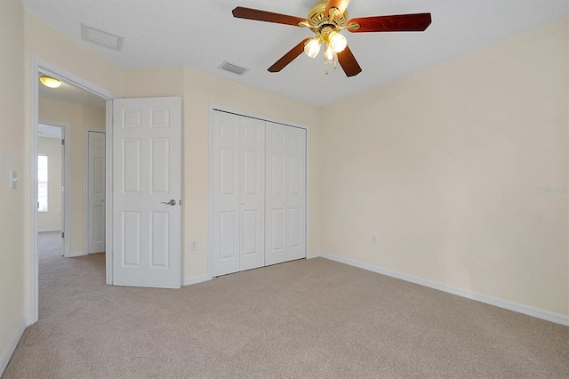 unfurnished bedroom featuring ceiling fan, a closet, and light carpet