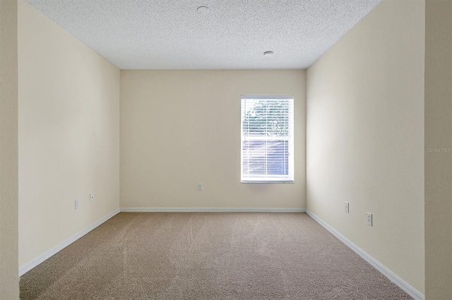 carpeted empty room with a textured ceiling