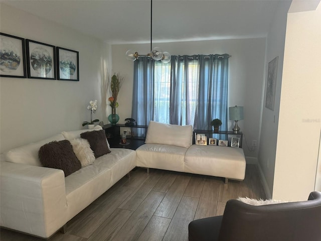 living room with dark wood-type flooring and a chandelier