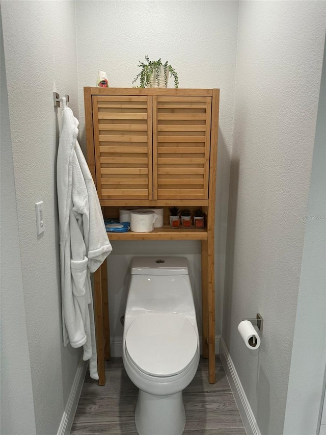 bathroom featuring hardwood / wood-style flooring and toilet