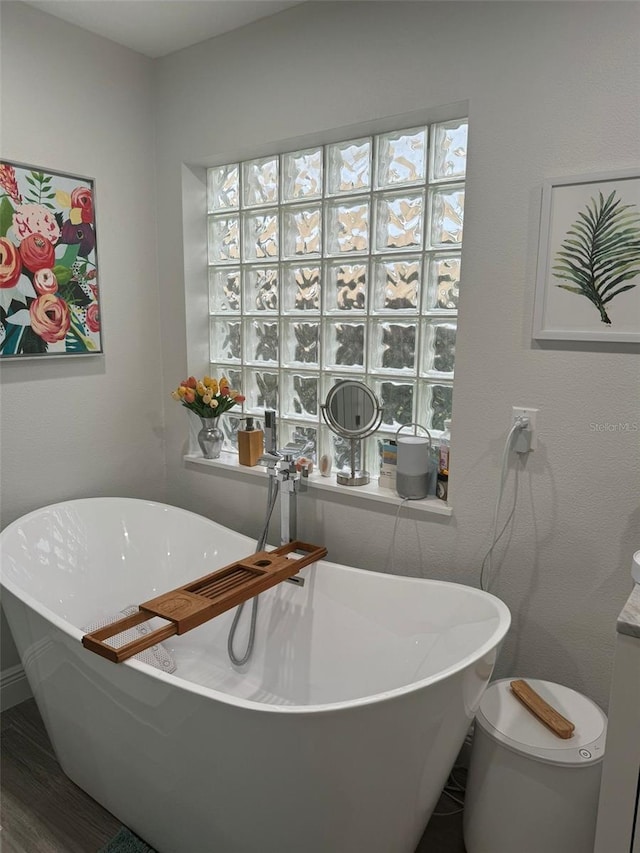 bathroom with a washtub and wood-type flooring