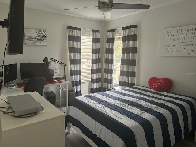 bedroom with hardwood / wood-style floors, ceiling fan, and a textured ceiling