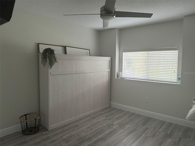 unfurnished bedroom with hardwood / wood-style floors, ceiling fan, a textured ceiling, and a closet