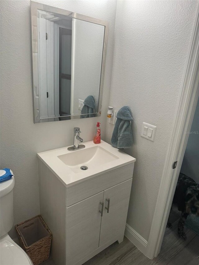 bathroom featuring hardwood / wood-style flooring, vanity, and toilet