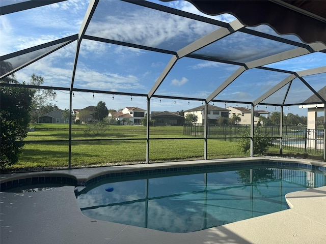 view of swimming pool featuring a lanai and a lawn